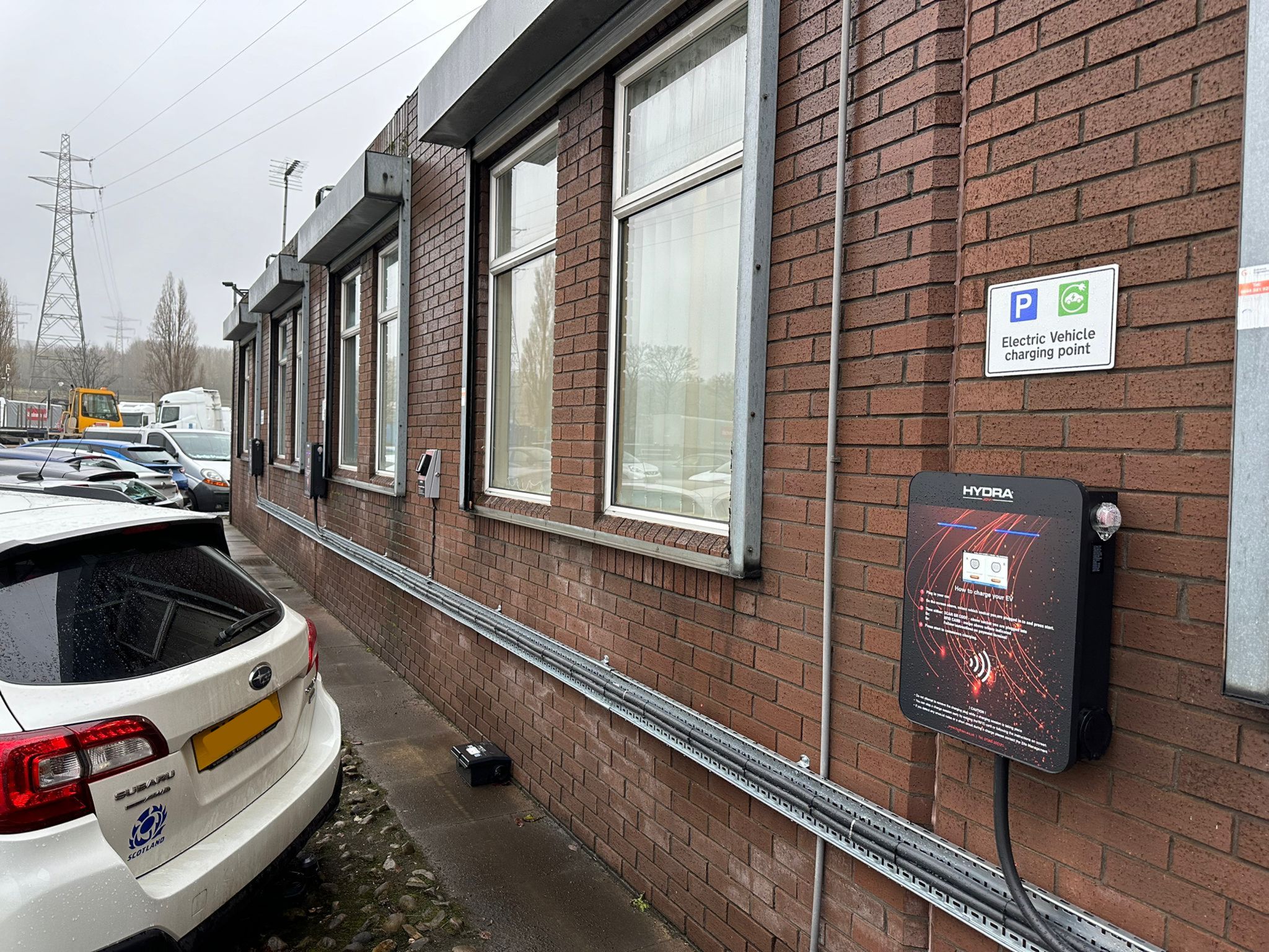 A row of three sleek AC 22kW workplace charge points installed neatly in a staff car park. These charging station provide convenient and efficient charging solutions for electric vehicles supporting eco-friendly transportation initiatives in the workplace
